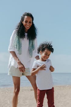 Happy mother and child enjoying a playful summer day at the beach, capturing moments of joy and laughter.